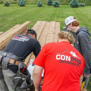 People cutting wood outside. Wearing ConPro shirts