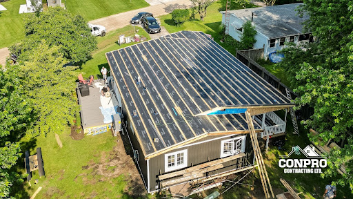 Aerial view of a house under construction with roofing framework and construction materials around